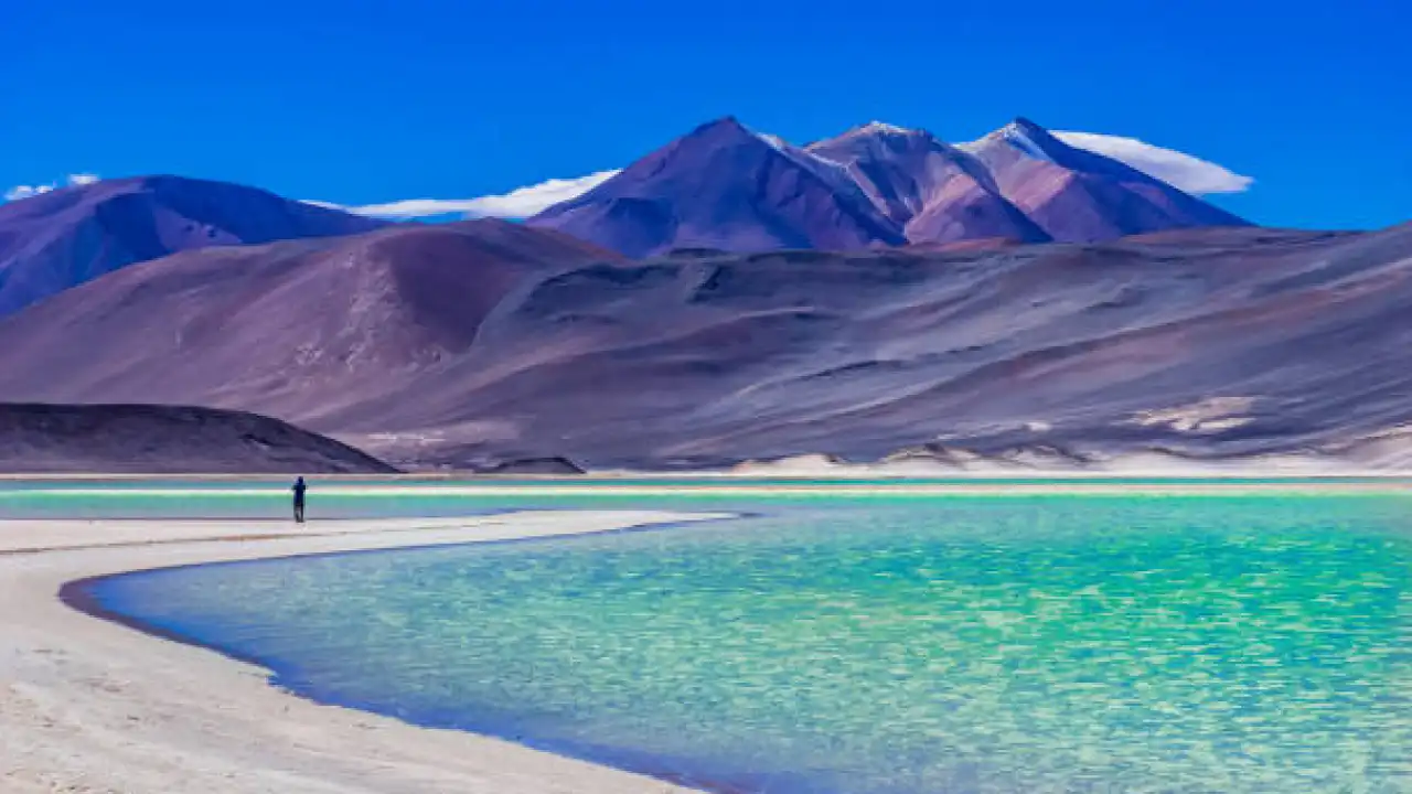 Paisagem do deserto de San Pedro de Atacama com lagoa e montanhas ao fundo