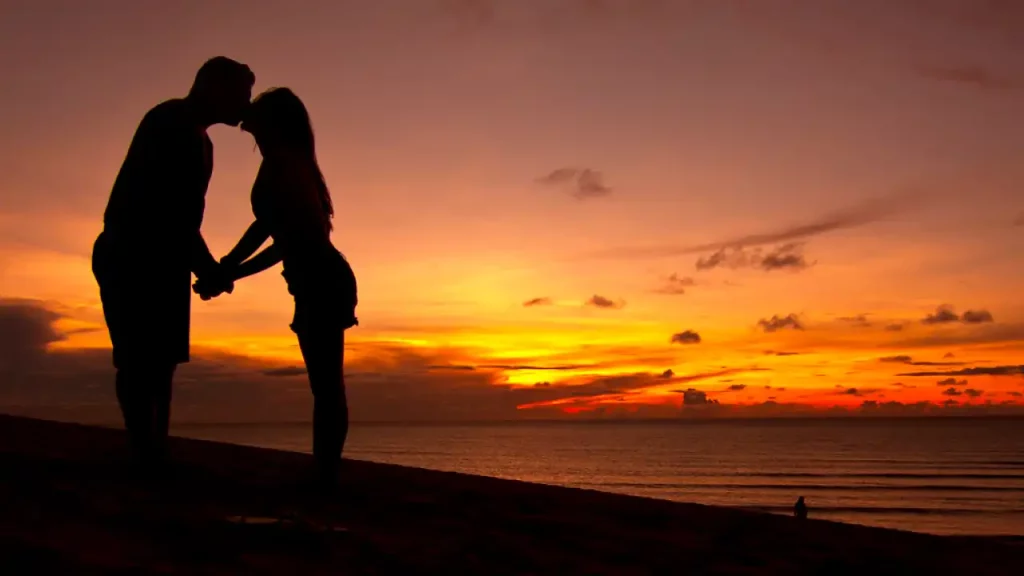 Casal se beijando em duna do por do sol de Jericoacoara