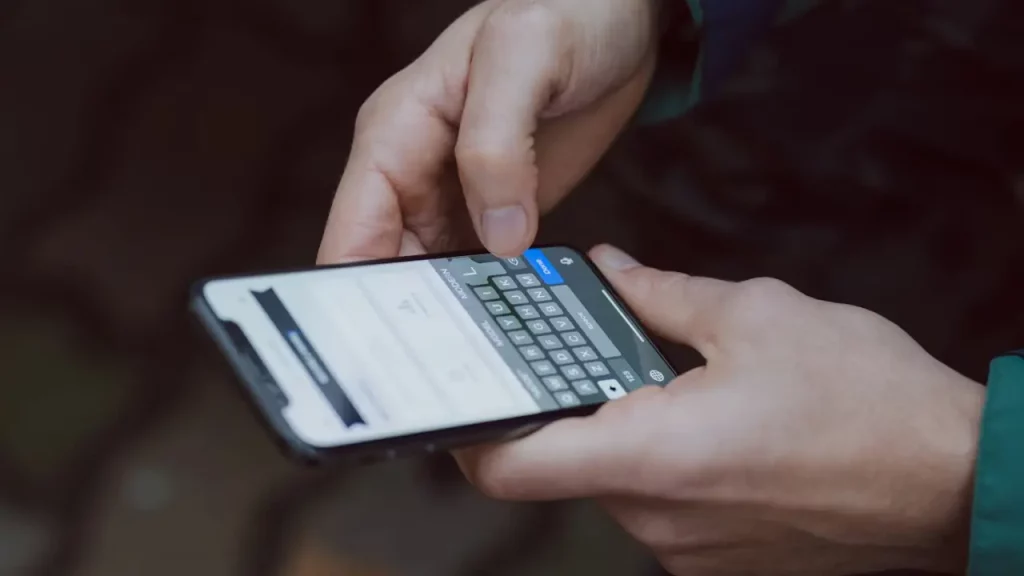 Pessoa digitando em um smartphone, preparando-se para enviar uma mensagem ou realizar uma busca.