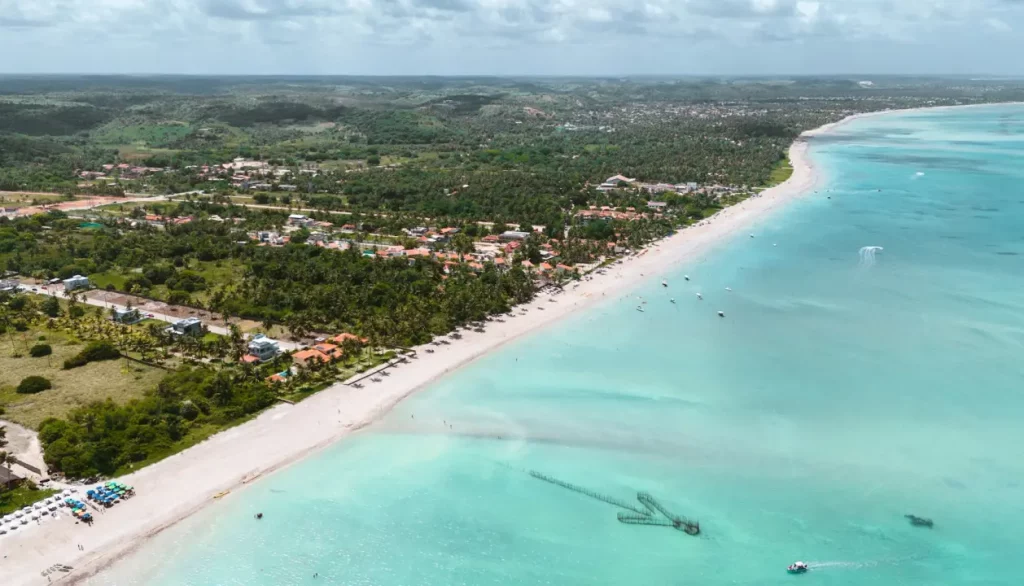 Barco ancorado nas águas rasas do Caminho de Moisés em Maragogi, um fenômeno natural que revela um banco de areia durante a maré baixa.