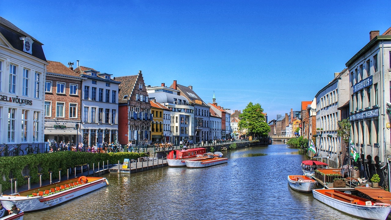 Os pitorescos canais de Gante, uma das cidades mais charmosas da Bélgica, com seus barcos e arquitetura medieval.