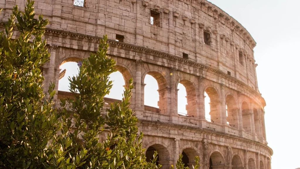 Imagem do Coliseu em Roma, iluminado pelo sol. Um dos monumentos mais icônicos e históricos da cidade, representando a grandiosidade da arquitetura romana.