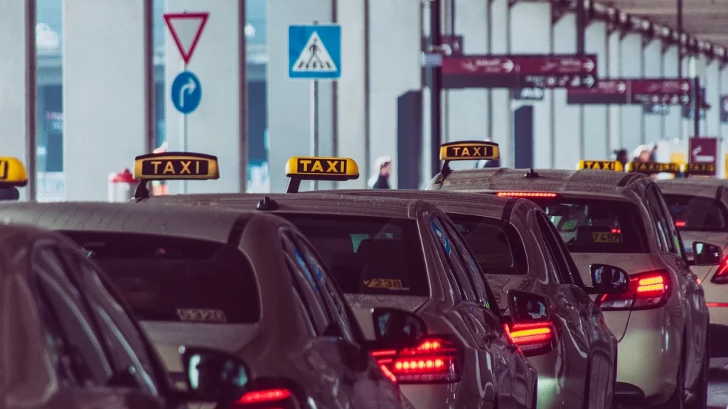 Fila de taxis esperando pasajeros en el aeropuerto de Cancún, destacando la necesidad de evitar estos servicios para no gastar en exceso.