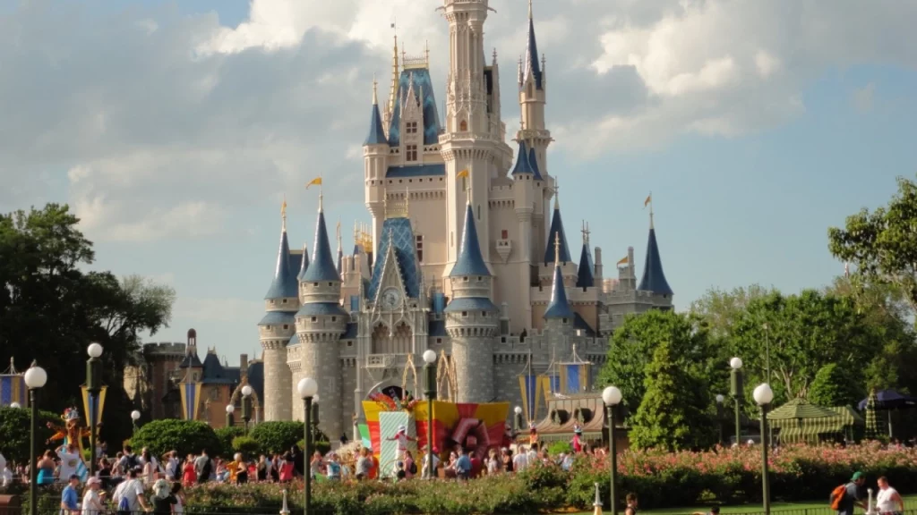 Castelo icônico da Cinderela no Magic Kingdom, Walt Disney World, na Flórida, com vários visitantes caminhando e aproveitando o parque ao fundo em um dia ensolarado.