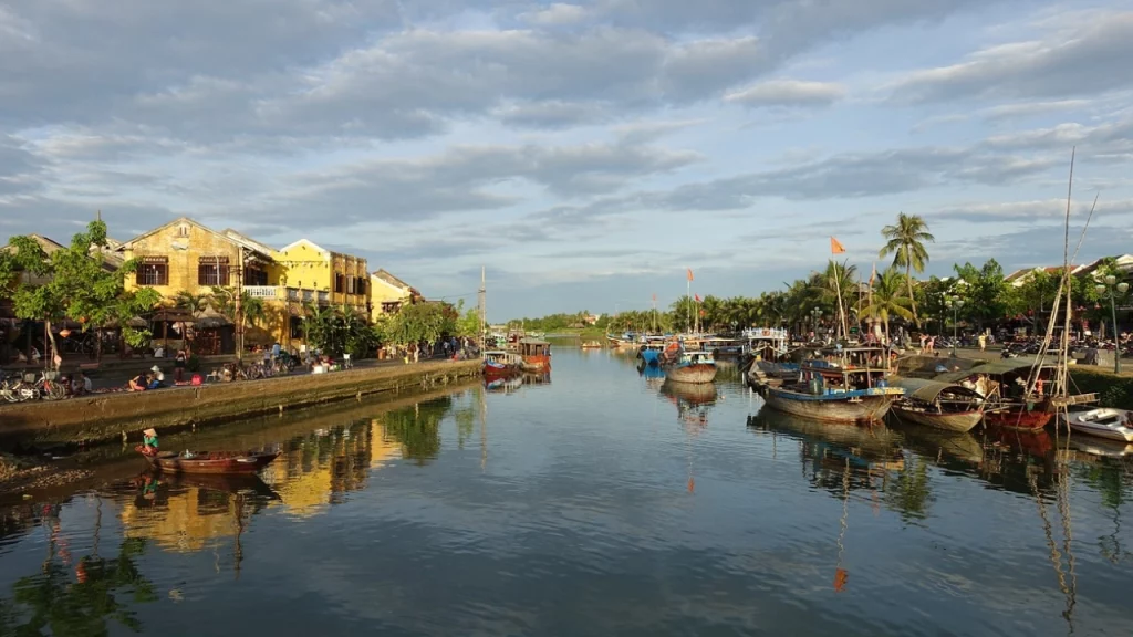 O charmoso canal da cidade histórica de Hoi An, cercado por barcos e arquitetura tradicional vietnamita.