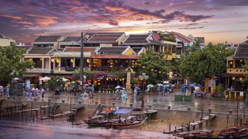  Cenário colorido e vibrante de Hoi An, Vietnã, ao entardecer, com lanternas e barcos tradicionais ao longo do rio.