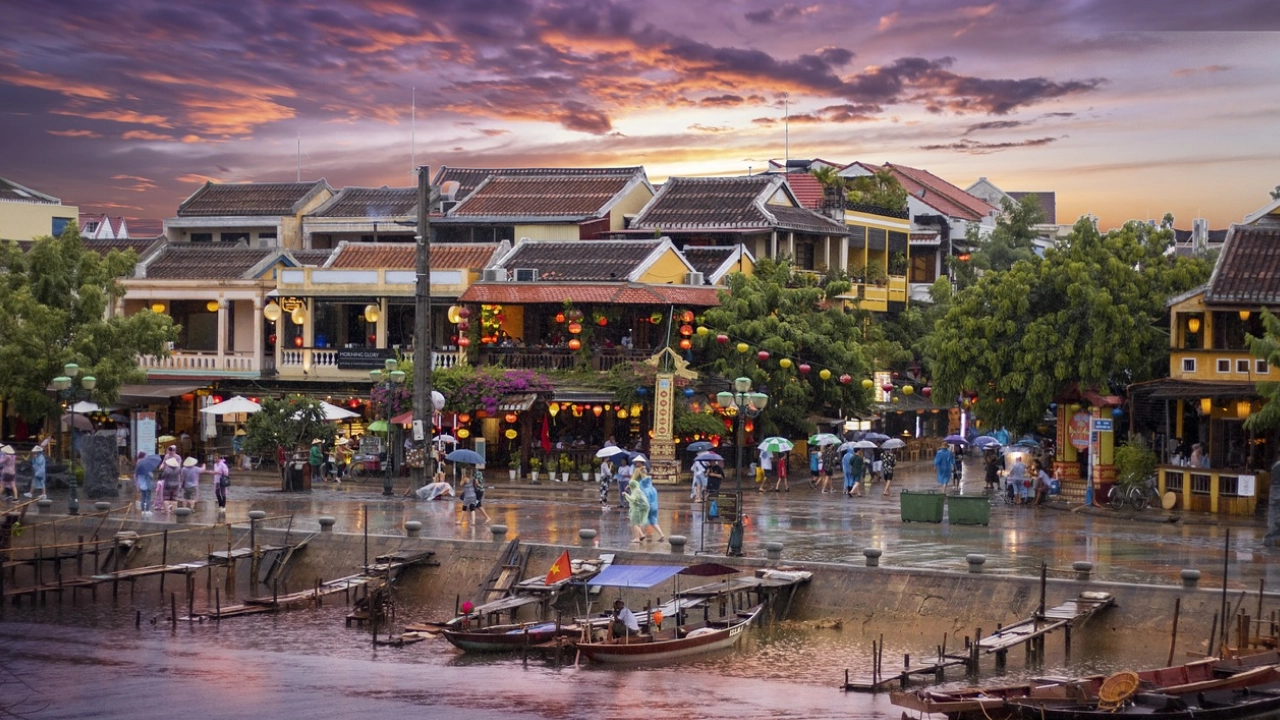 Cenário colorido e vibrante de Hoi An, Vietnã, ao entardecer, com lanternas e barcos tradicionais ao longo do rio.