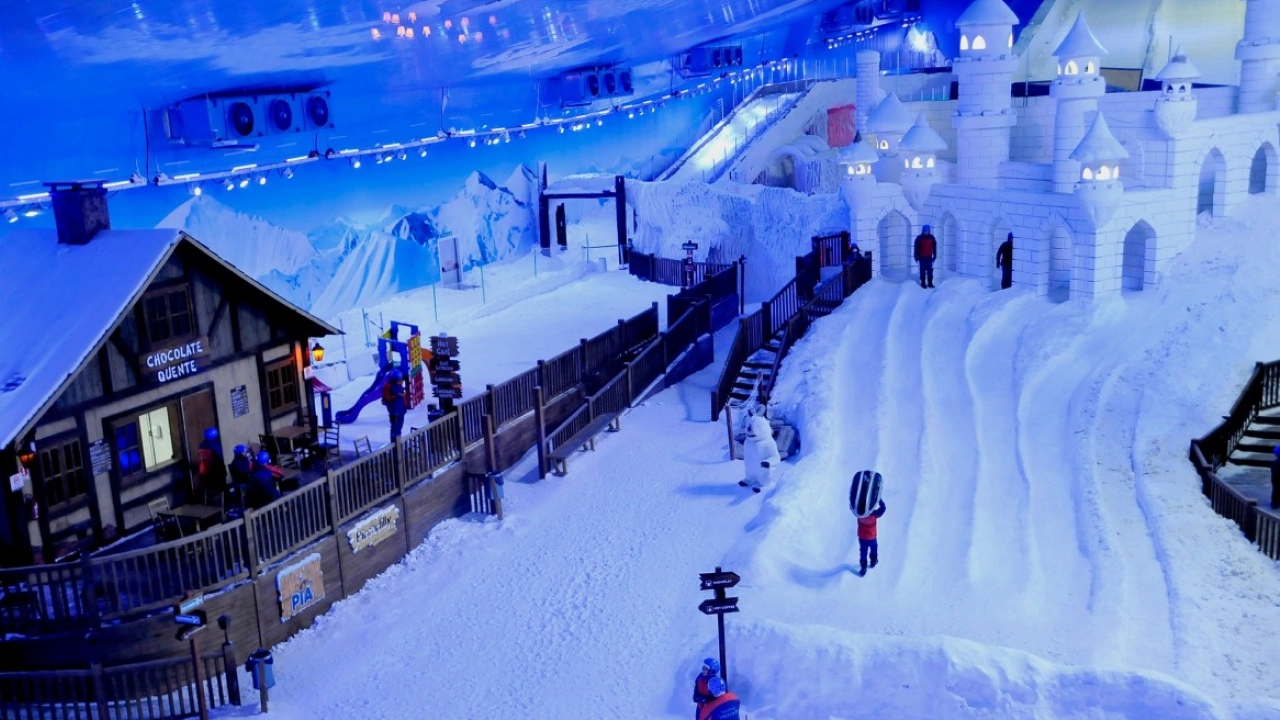 Vista interna do parque Snowland em Gramado, com estrutura coberta de neve artificial, mostrando uma área temática que inclui uma vila, pistas de esqui e uma atmosfera encantadora para atividades de inverno.