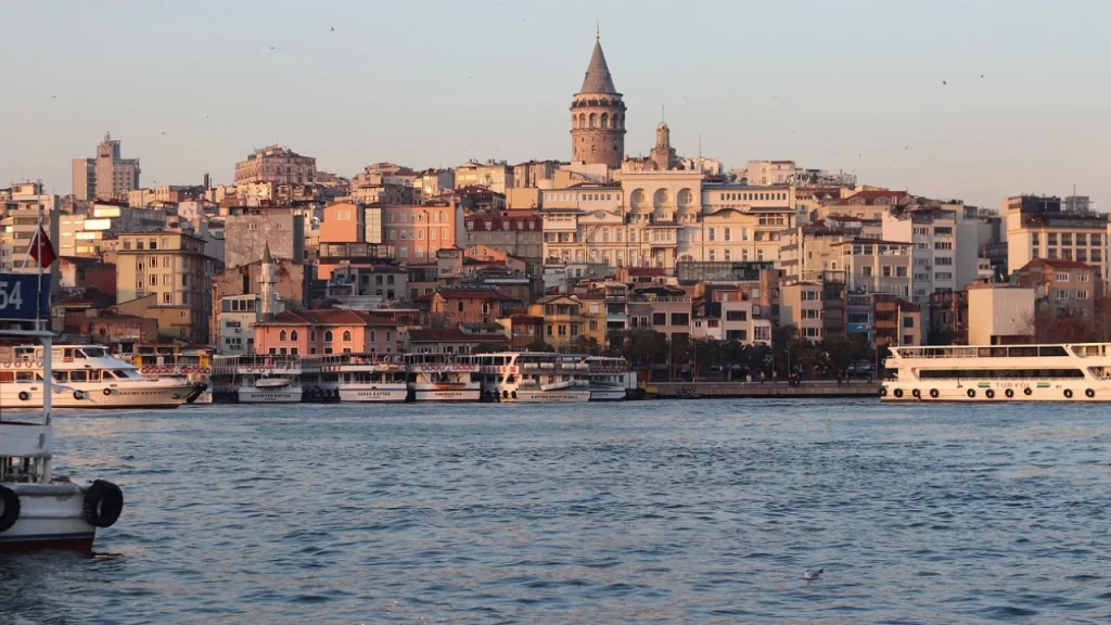 Vista do bairro de Karaköy e da Torre de Gálata, em Istambul, com barcos no Estreito de Bósforo.