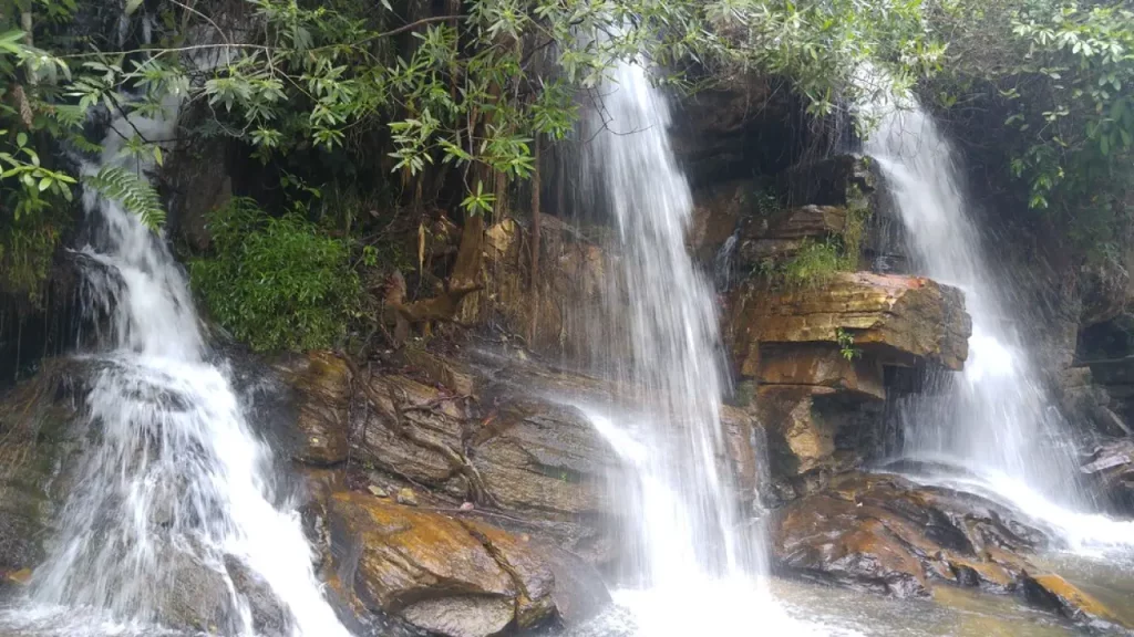 Cachoeira com diversas quedas d’água em meio a rochas e vegetação, cenário típico das atrações naturais de Pirenópolis.