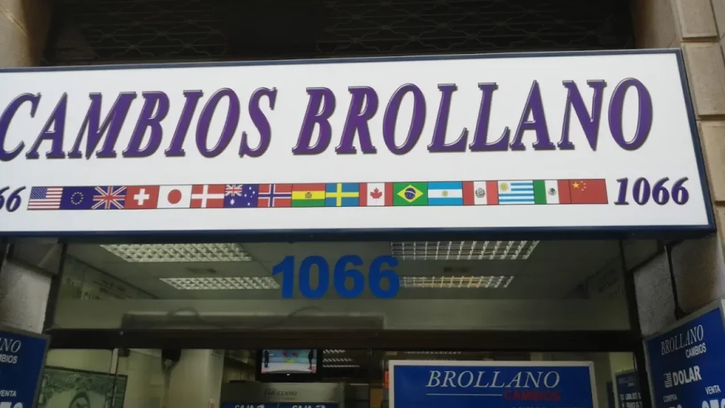 Fachada da casa de câmbio Brollano em Santiago, Chile, com bandeiras de diversos países e o número 1066.