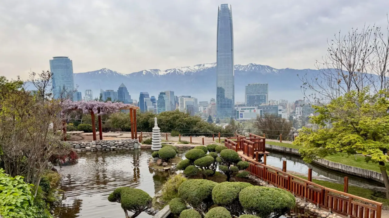 Paisagem de Santiago, capital do Chile, com o skyline da cidade, a Cordilheira dos Andes ao fundo e o Jardim Japonês em primeiro plano.