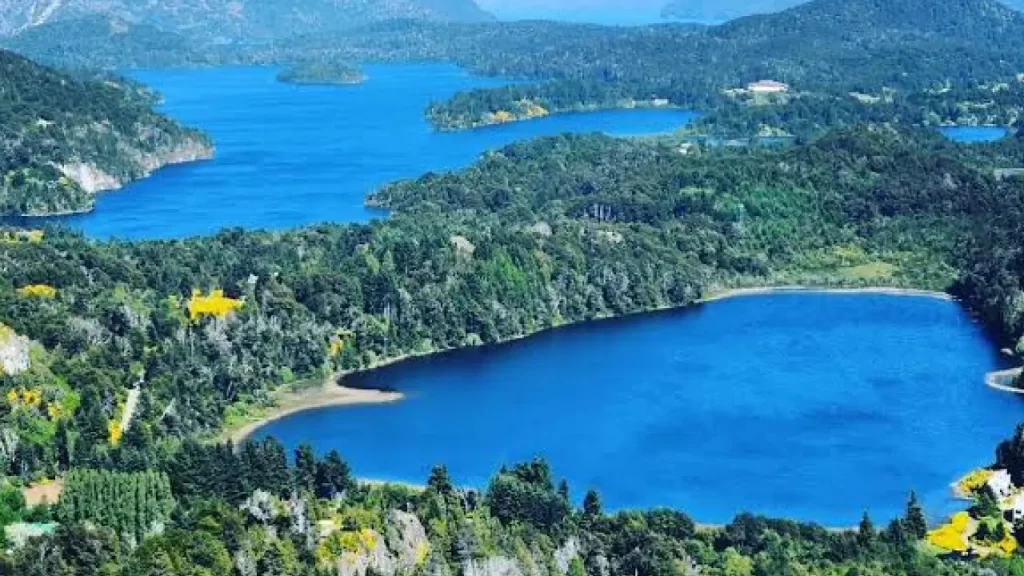 Vista panorâmica de lagos azuis rodeados por florestas e montanhas no Circuito Chico, Bariloche.