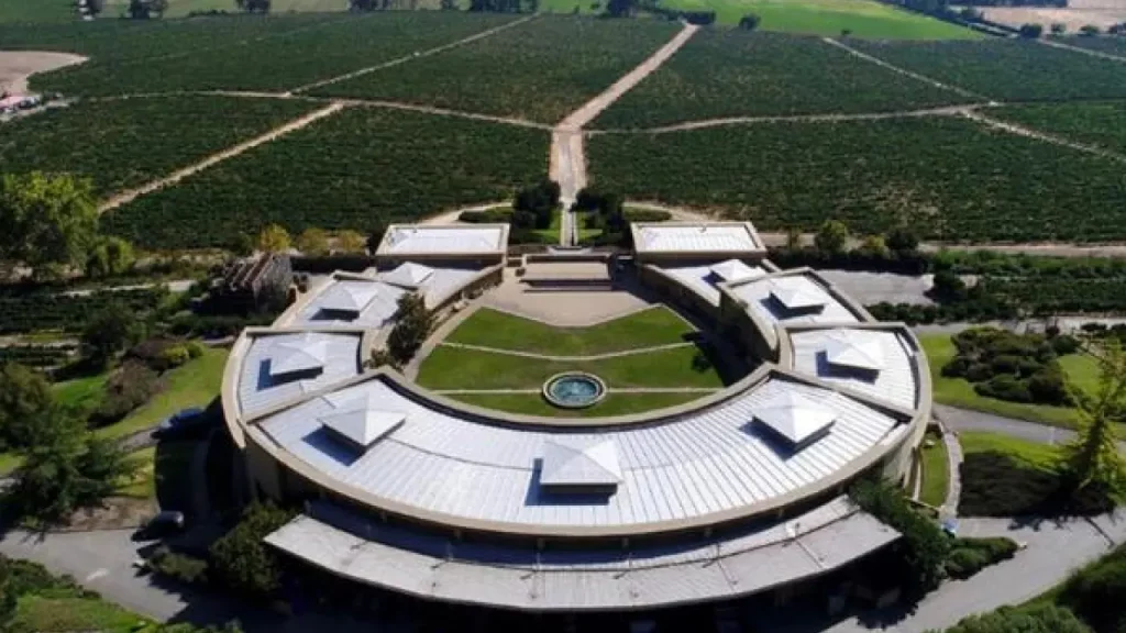 Vista aérea da vinícola Haras de Pirque no Chile, com arquitetura em forma de ferradura cercada por plantações de uvas.