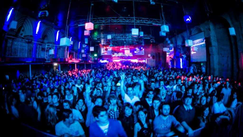 Público lotando a pista da Blondie, balada alternativa no centro de Santiago, com iluminação azul e atmosfera de festa.
