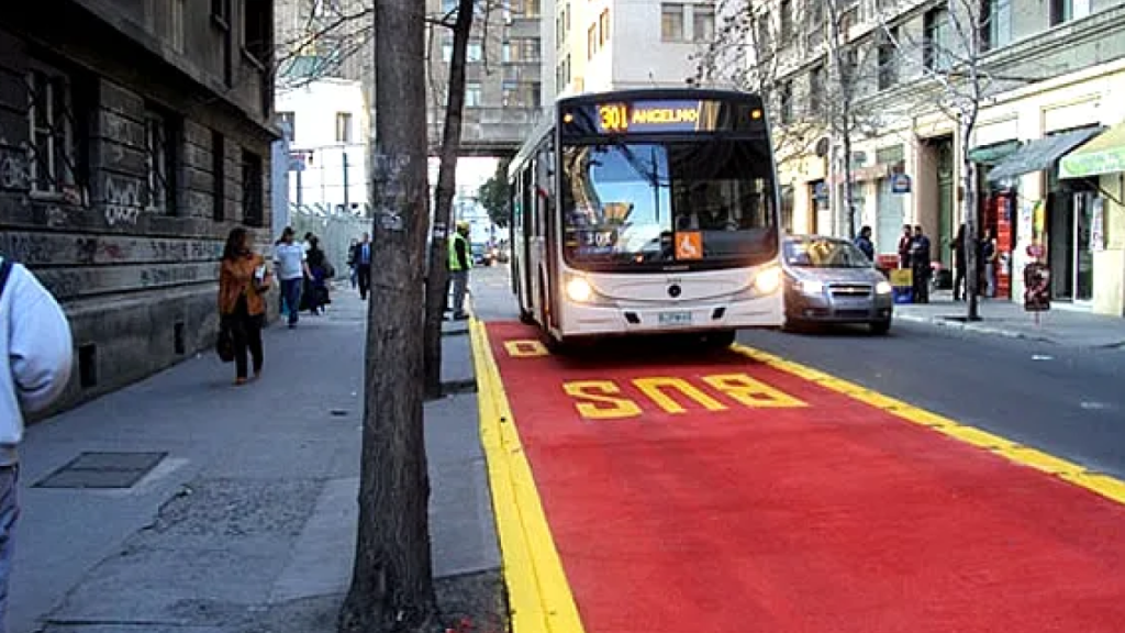 Ônibus do transporte público trafegando por faixa exclusiva vermelha no centro de Santiago, Chile.