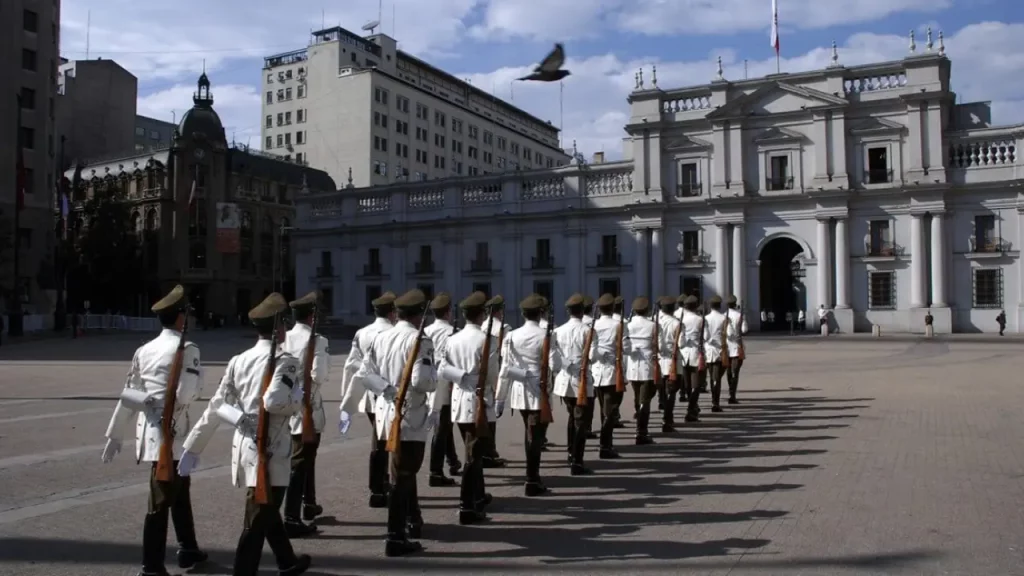 Soldados marchando em formação em frente ao Palácio de La Moneda, durante cerimônia de troca da guarda em Santiago do Chile.
