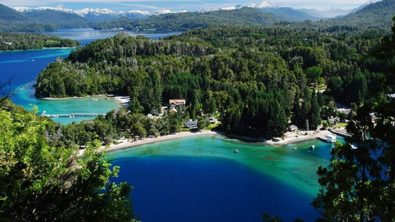 Baías Brava e Mansa em Villa La Angostura, águas azuis cercadas por bosques e montanhas.