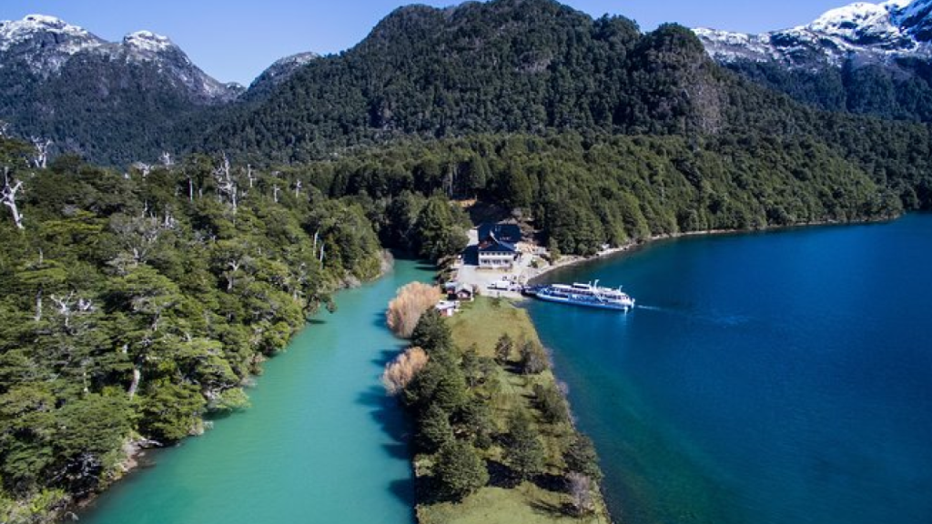Confluência do Río Frías (verde) com o Lago Nahuel Huapi (azul) em Puerto Blest, píer e barco ao fundo.