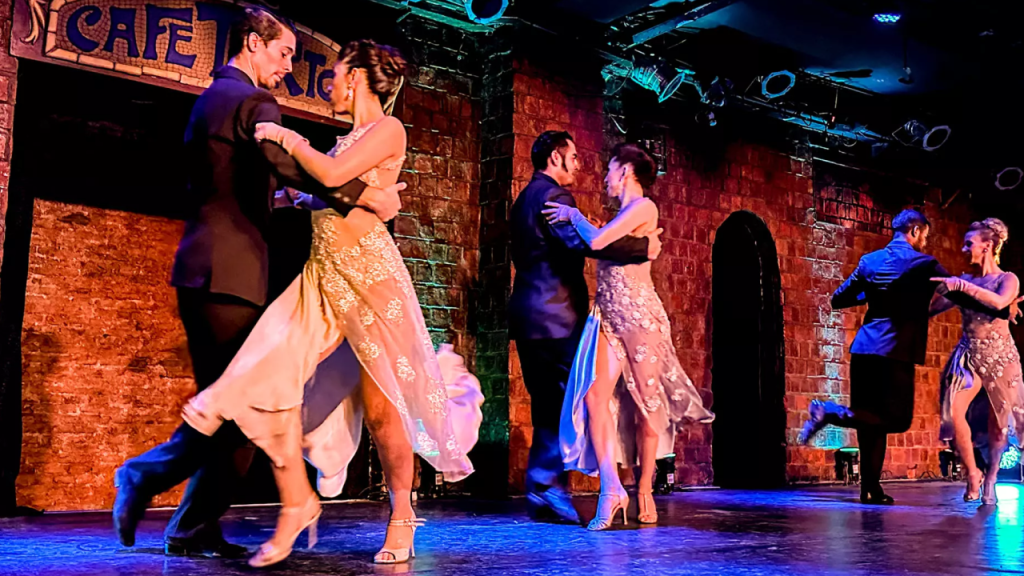 Casais dançando tango no palco em Buenos Aires.