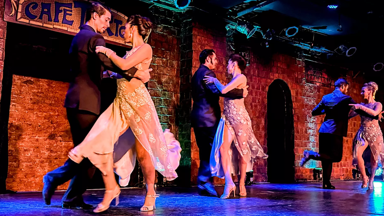 Casais dançando tango no palco em Buenos Aires.