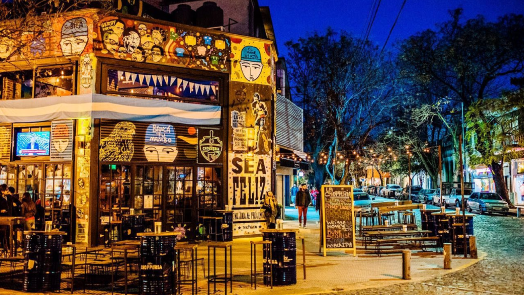 Rua iluminada em Palermo, Buenos Aires, com bares e restaurantes.